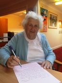 Bethel House resident, Sheila Clarke signing her letter to a prospective pen-friend.
