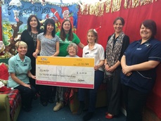 Staff members from Westfield Lodge present Macmillan with a cheque.