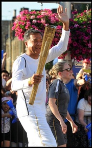 Dr Chai Patel carrying the Olympic Torch through Ealing