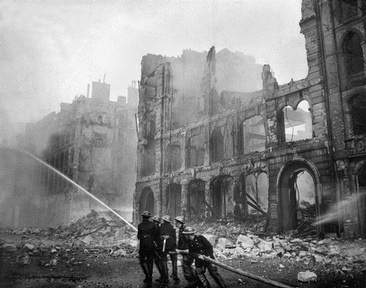 The Blitz: Firefighters tackle building fires in a London street bombed by Hitler in 1941.