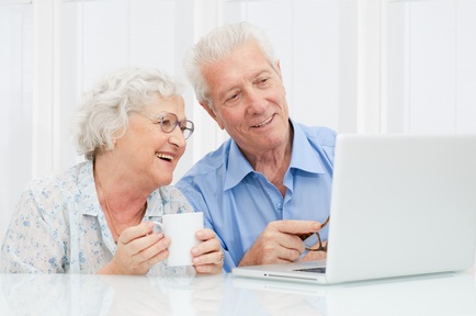 Two older people using a computer