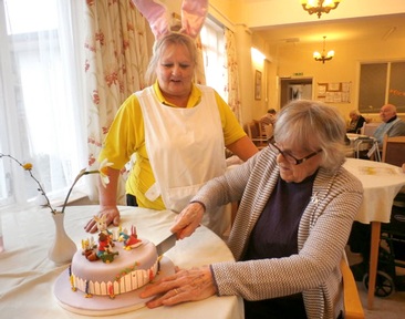 Alexandra House resident, Eileen cutting their Easter cake
