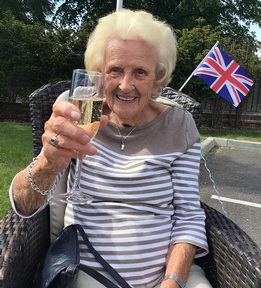 Delighted resident Audrey sips champagne in the sun. Credit: Gracewell of Bookham