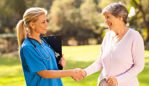 An older lady shaking hands with her carer, representing making a good choice of care home